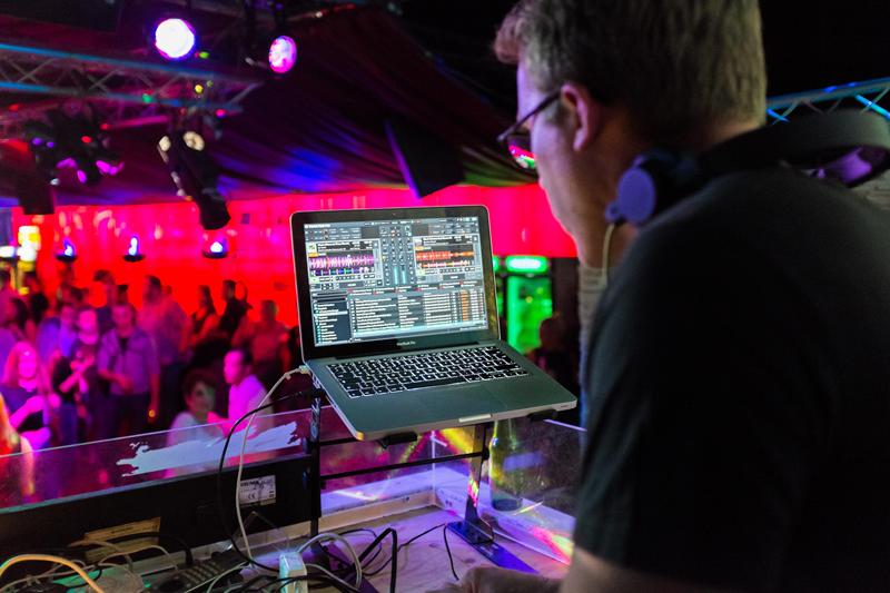 A DJ with a computer playing a mix